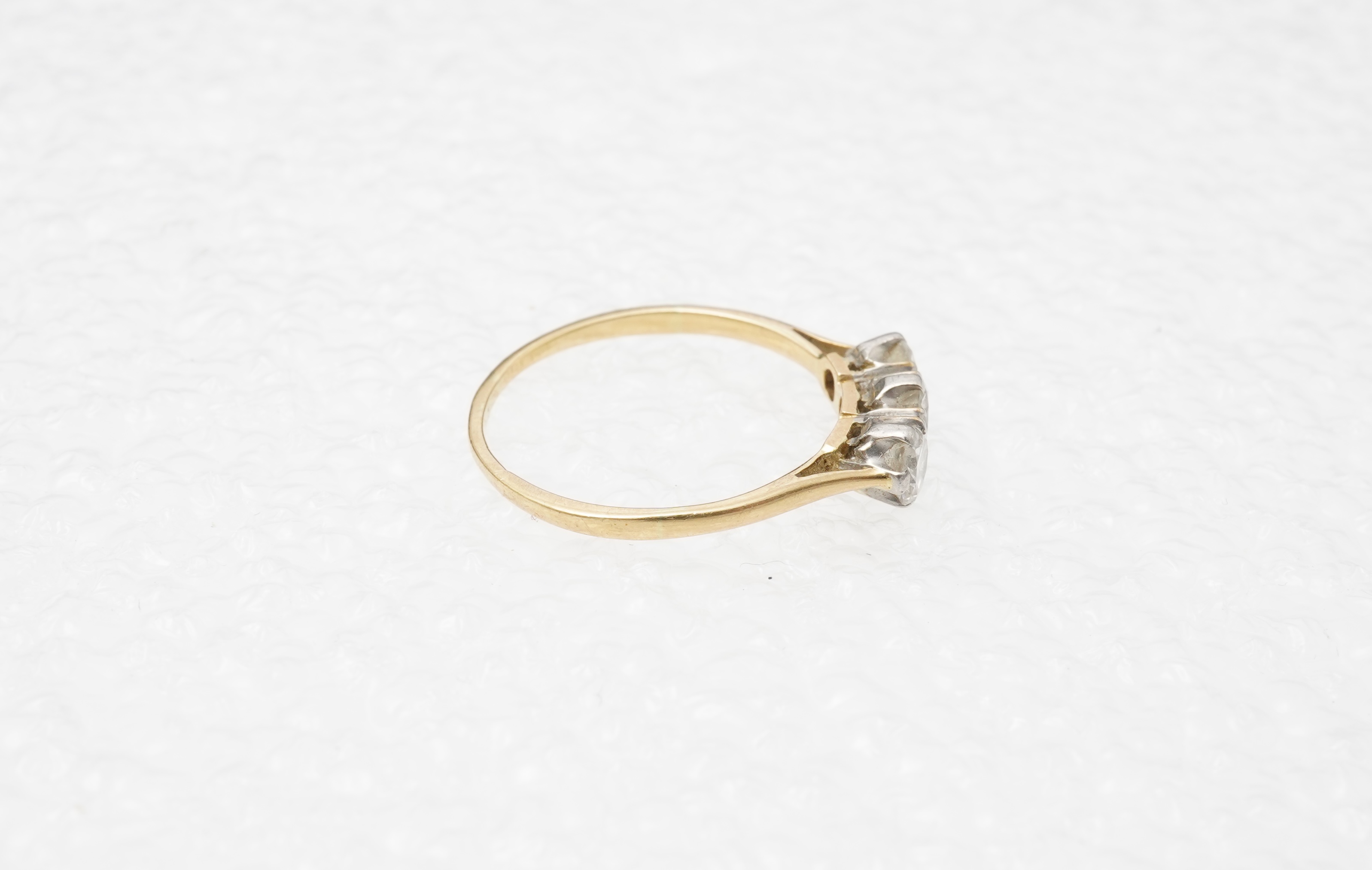 A diamond three-stone ring, set with three circular-cut diamonds totalling approximately 0.50 carats, mounted in gold, size O, stamped 18CT, gross weight approximately 2 grams